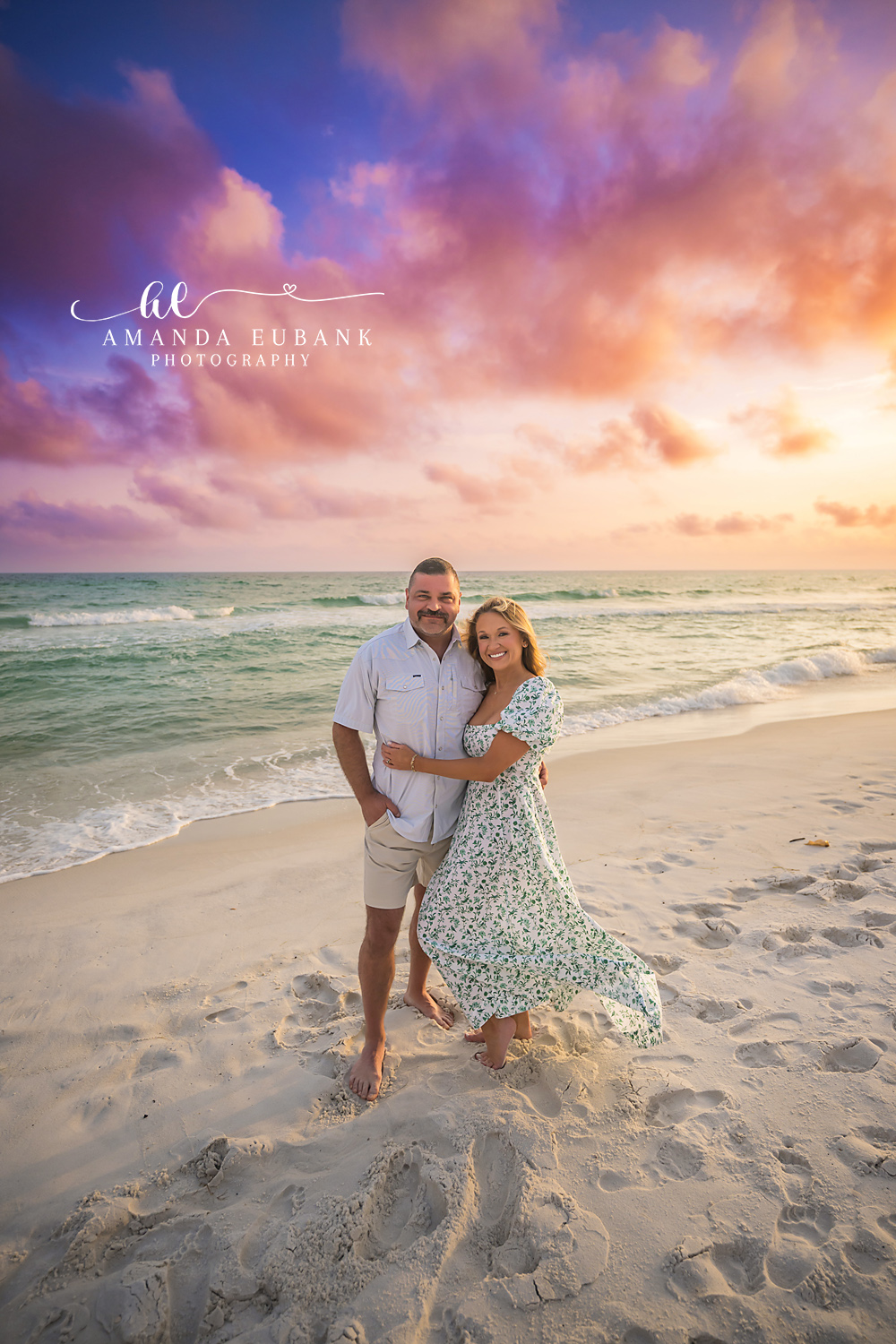 Family of Three in Floral | Tampa Family Photographer A family of three standing on the sand in floral and white under a purple sky during a Tampa family photography session.