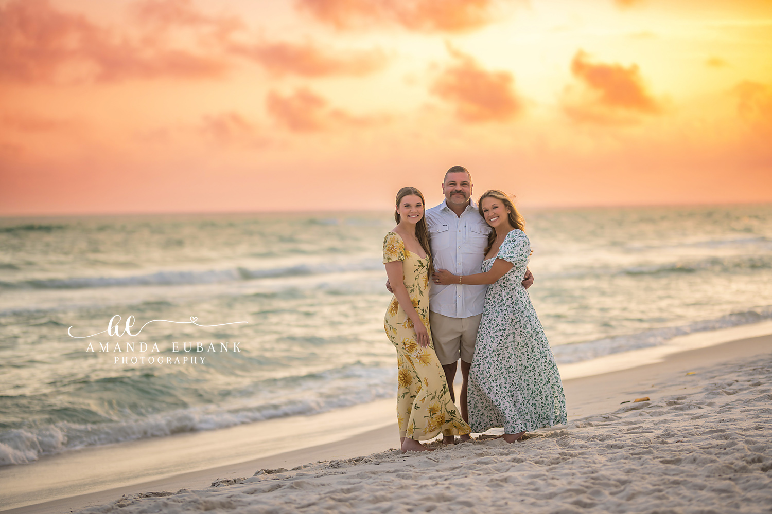 Dad and His Daughters | Tampa Beach Family Photography Tampa family photographer captures a father standing between his two daughters in floral dresses at sunset.