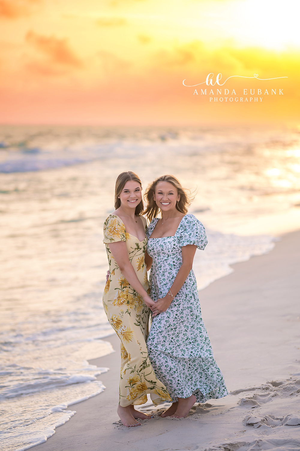 Mother and Daughter Portrait | Family Photographer in Tampa, Florida Family beach portraits in Tampa, FL showing a mother and daughter standing together on the beach in floral dresses.