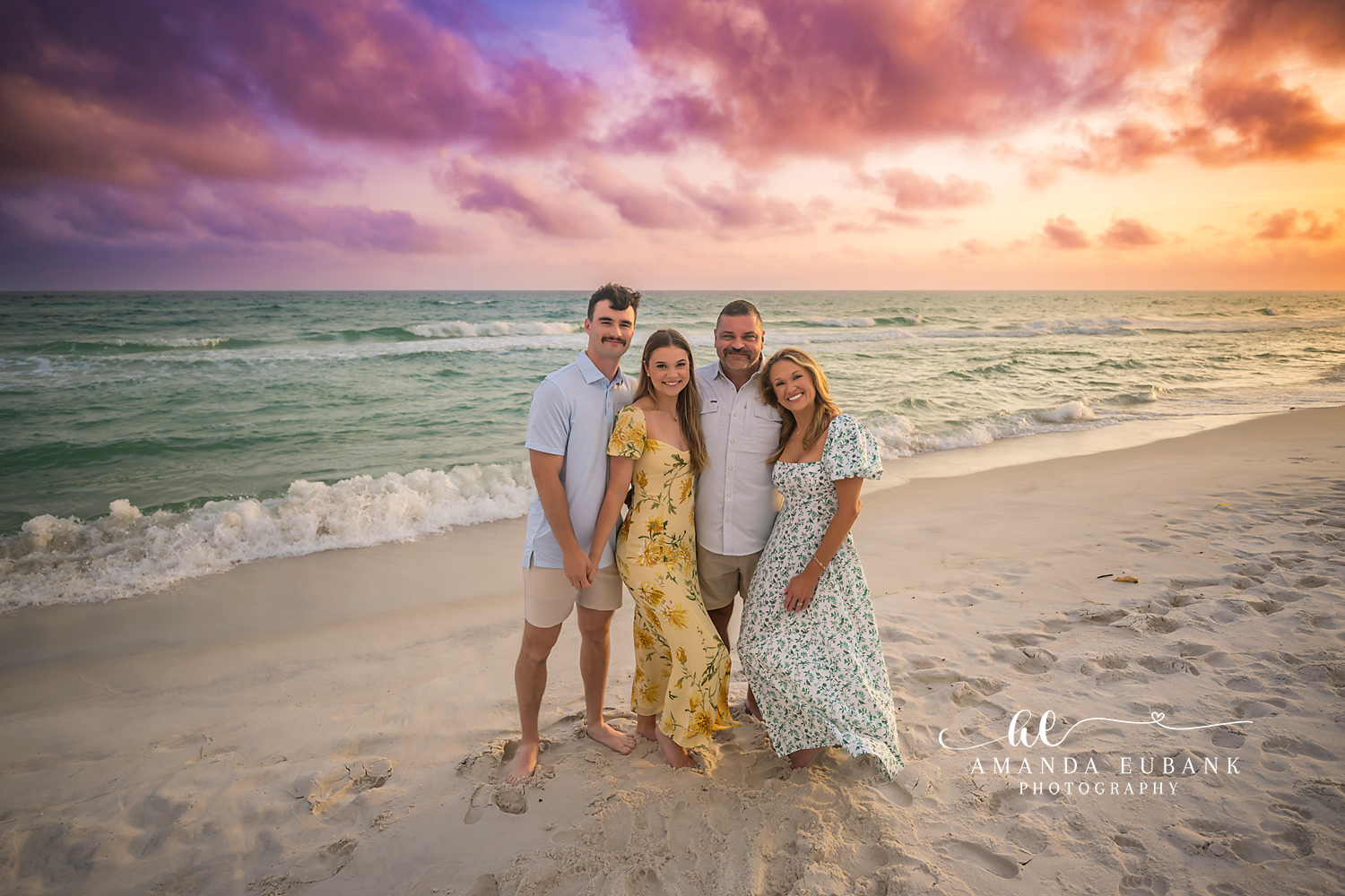 Family of Four in Florals | Tampa Beach Family Photography Tampa family photographer captures a family of four standing on the sand in yellow and floral at pastel sunset.