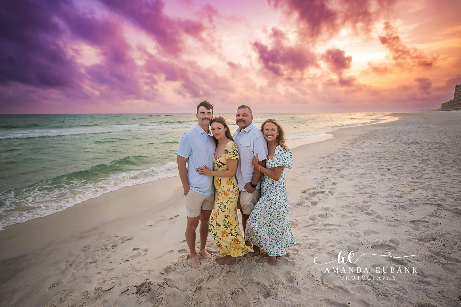 Family in Yellow and Blue | Tampa Beach Family Photography Tampa family photographer captures a family of four on the beach in yellow and blue beneath purple sunset clouds.