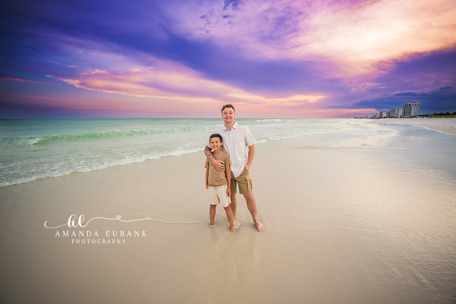 Standing in the Surf at Sunset — Tampa, FL Couples Session A couple standing together in the surf as purple light spreads overhead at a beach couples session near Tampa, Florida.