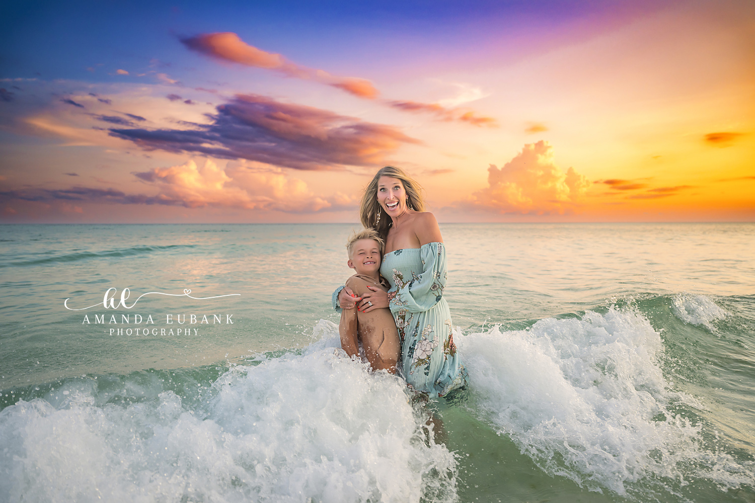 Mother and Son in the Waves | Tampa Beach Family Photography Tampa family photographer captures a mother holding her son as a wave breaks around them at golden hour.