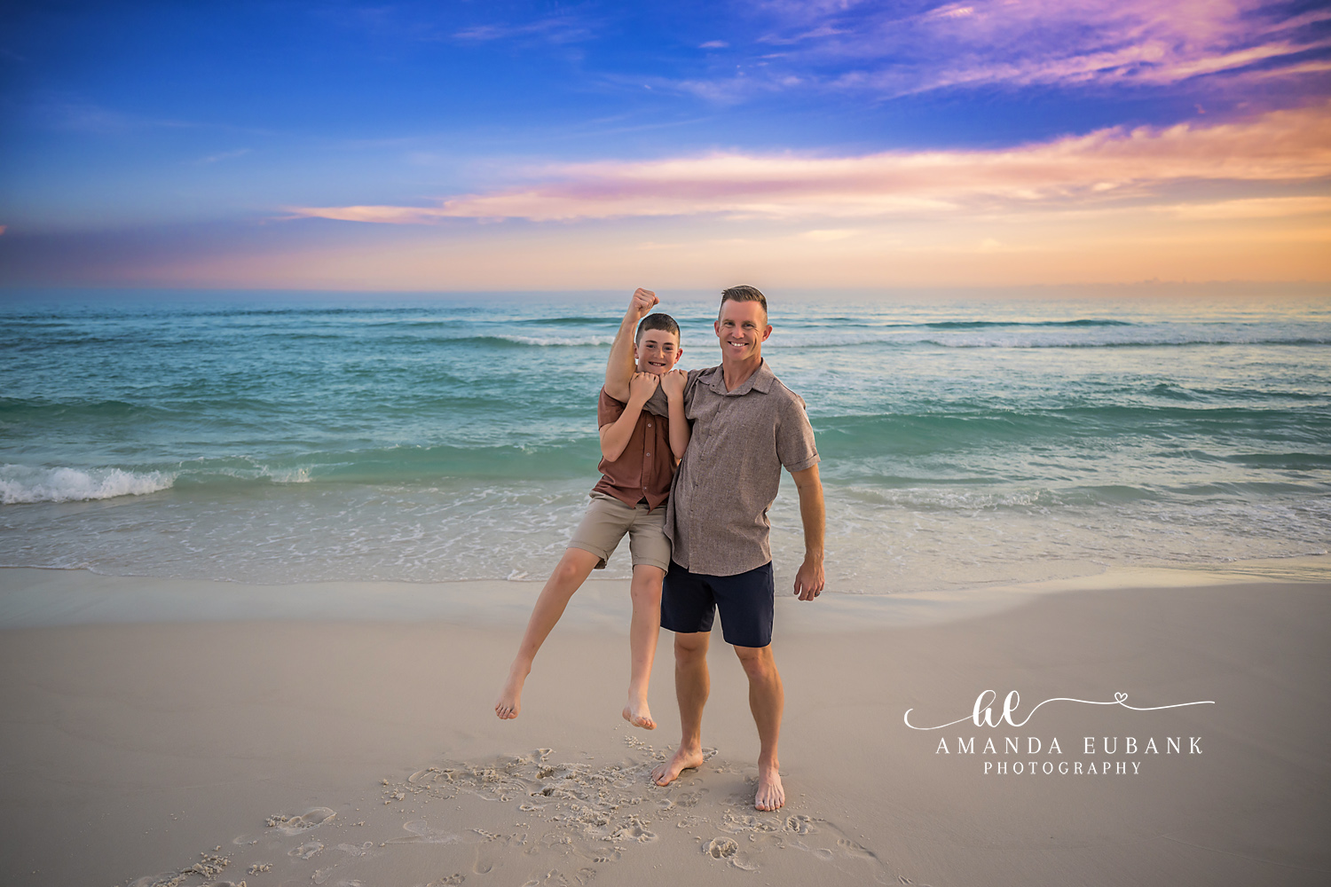 Parents and Daughter at Sunset | Tampa Beach Family Photography Tampa family photographer captures parents holding their daughter on the sand beneath a pink and gold sunset.