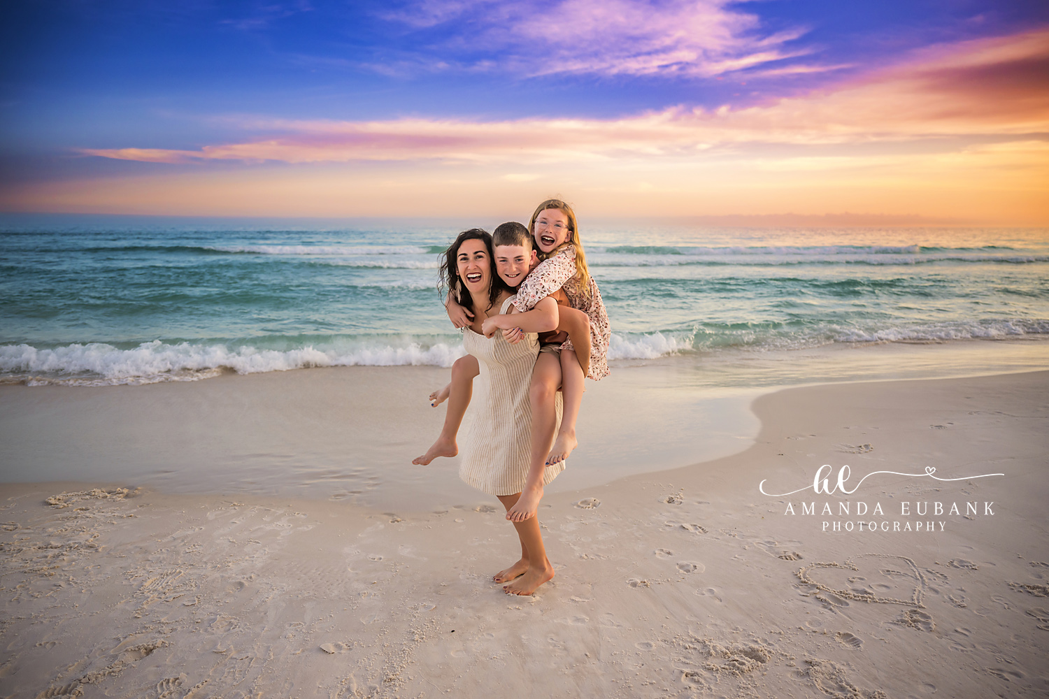 Mom and Kids on the Beach | Tampa Beach Family Photography Tampa family photographer captures a mother with her two children on the sand beneath a blue and gold sunset.