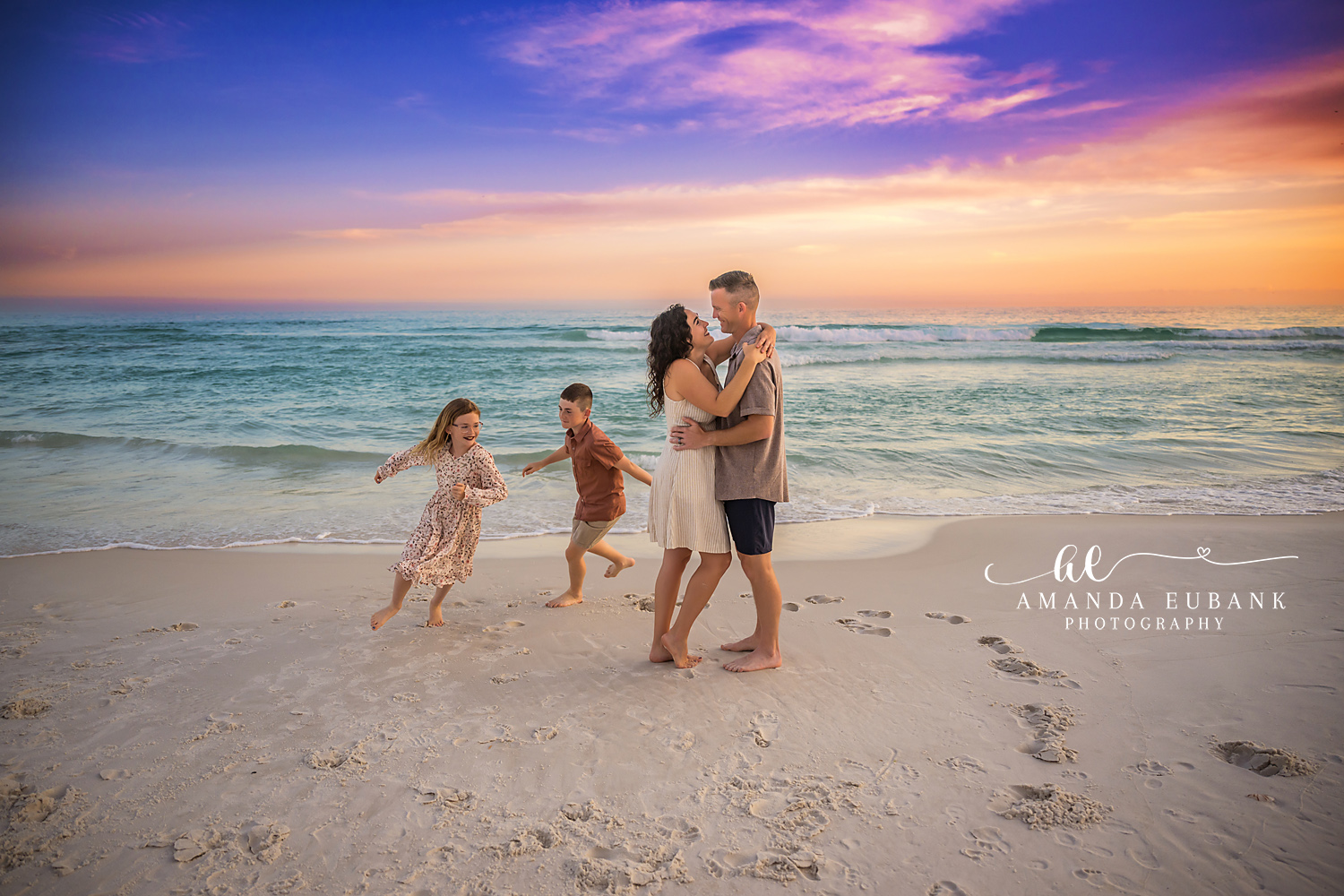 Girls Running to Their Parents | Tampa Family Photographer Two girls running across the sand toward their parents under a sunset sky during a Tampa family photography session.