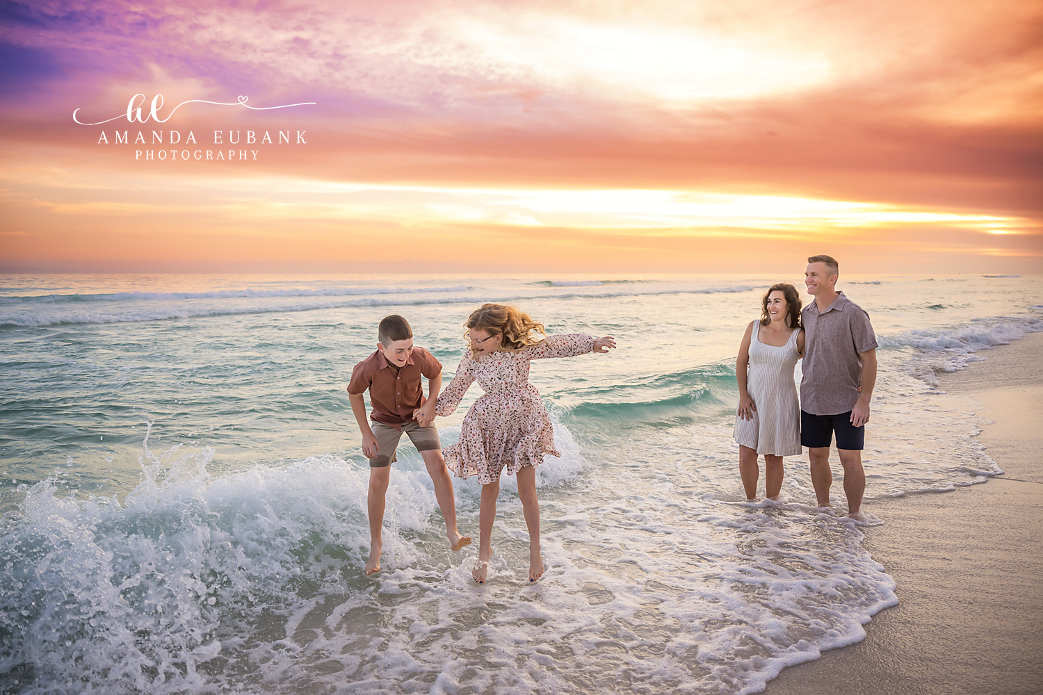Family Playing in the Waves | Family Photographer in Tampa, Florida Family beach portraits in Tampa, FL showing a family of four splashing through breaking waves as the sun burns gold.