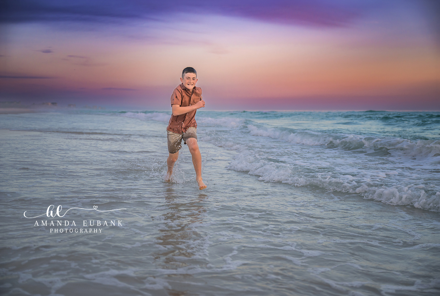 Girl Standing in the Waves — Tampa Bay Children’s Photography A girl in a floral dress standing in the surf under a purple and teal sky at a beach kids session in Tampa, FL.