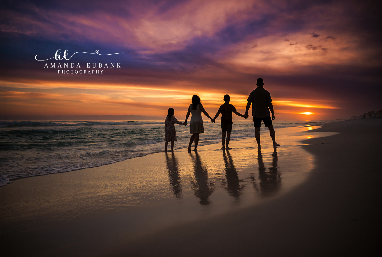 Family Silhouette on the Water — Tampa Bay Family Portraits A family of four silhouetted hand in hand as the sun melts into the Gulf — beach family photography in Tampa Bay.