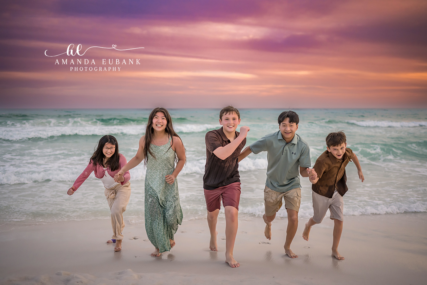 Family of Six Running in the Surf | Family Photographer in Tampa, Florida Family beach portraits in Tampa, FL showing a family of six running together through the shallow surf at sunset.