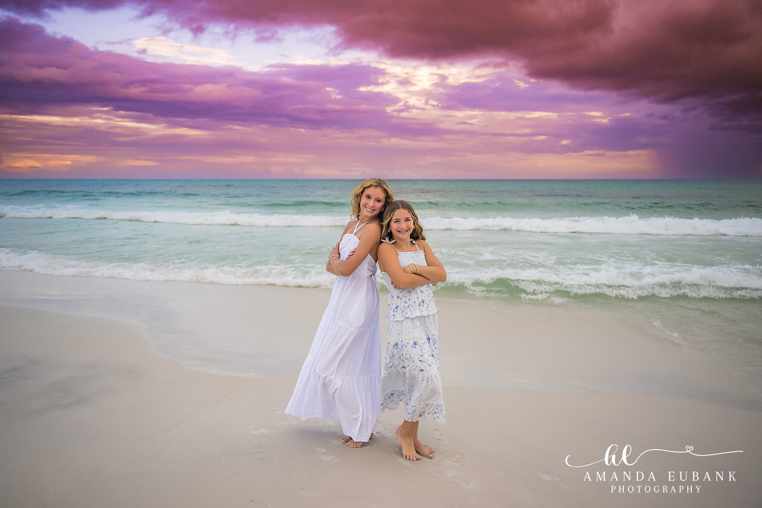 Mother and Daughter on the Shore — Tampa, FL Family Session A mother and daughter laughing together on the shoreline in white dresses at a beach family session near Tampa, Florida.