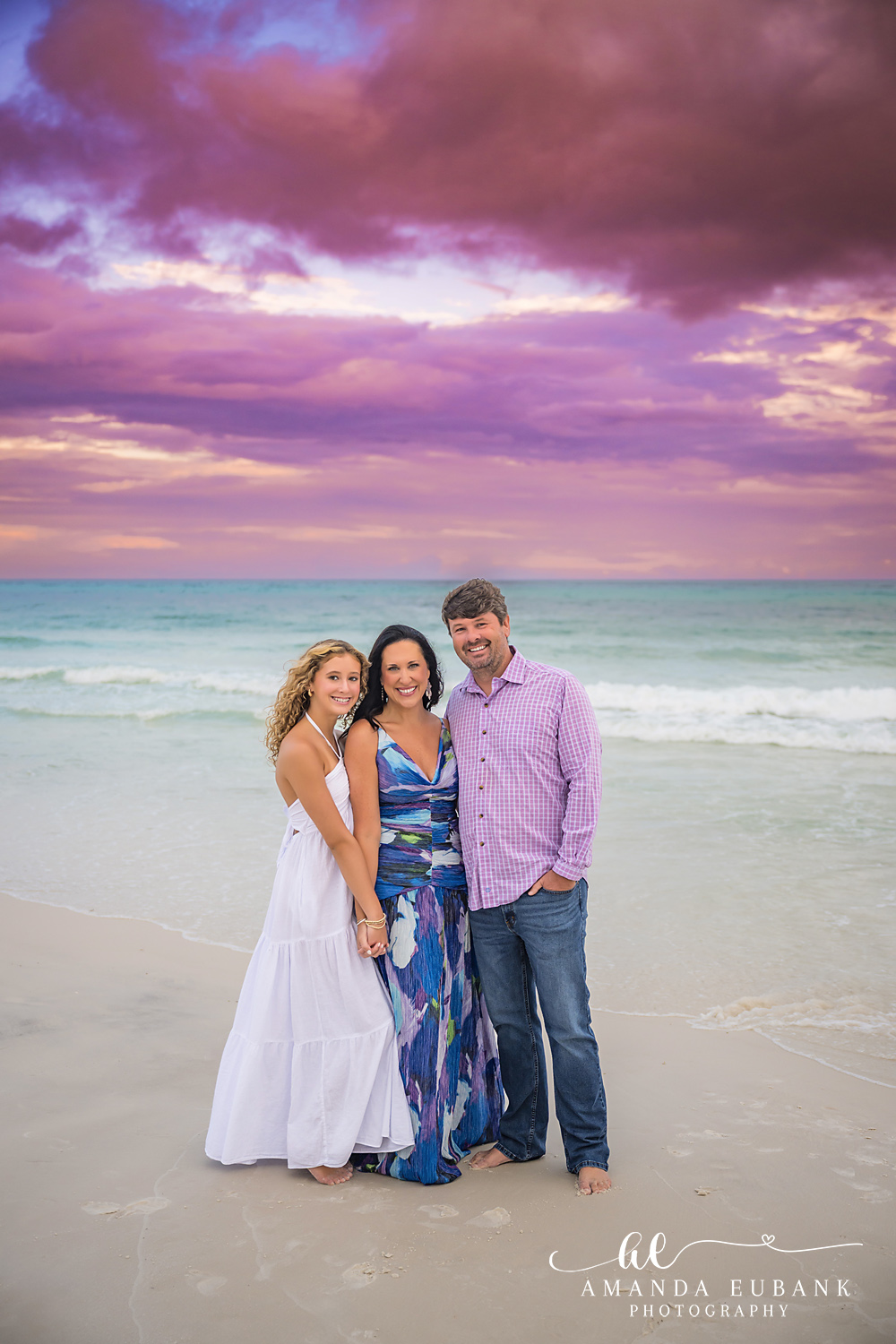 Family of Three in Navy — Tampa Bay Family Portraits A family of three standing together on the beach in navy and white at dusk — beach family photography in Tampa Bay.