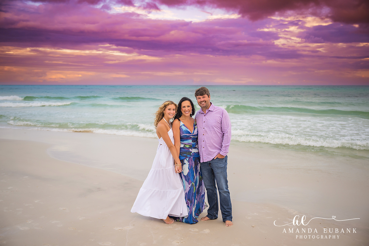 Family Portrait in Navy and White | Tampa Family Photographer A family of four on the sand in navy and white beneath a violet cloudscape during a Tampa family photography session.