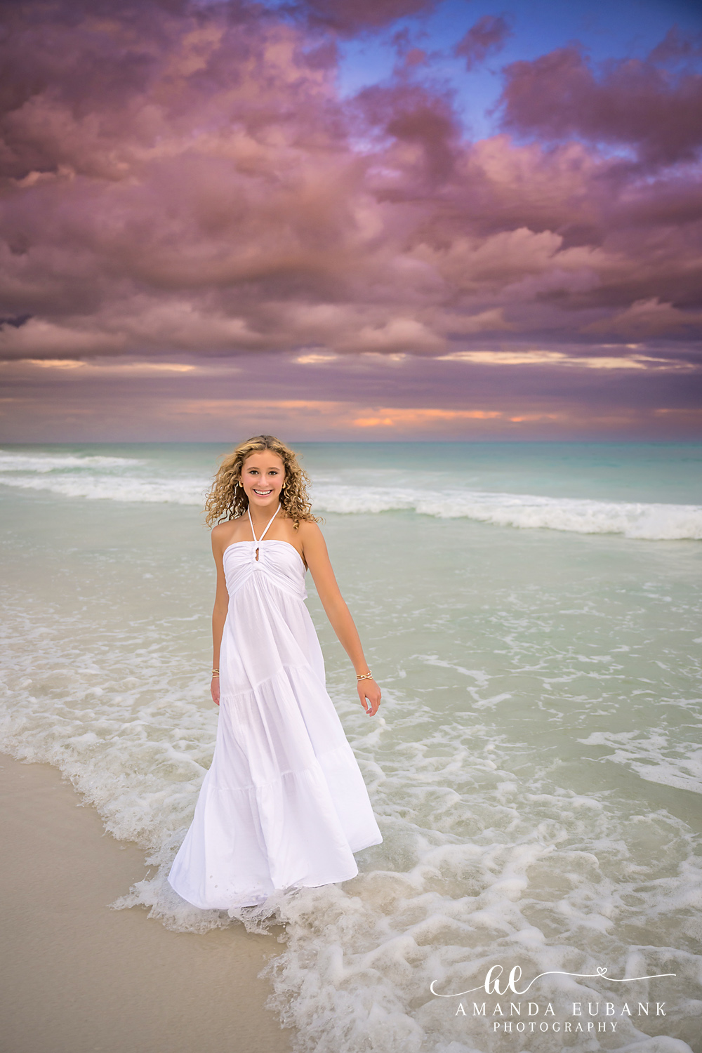 Senior Portrait in a White Gown | Tampa Senior Photographer A high school senior in a white gown standing on the white sand at dusk during a senior portrait session in Tampa, Florida.
