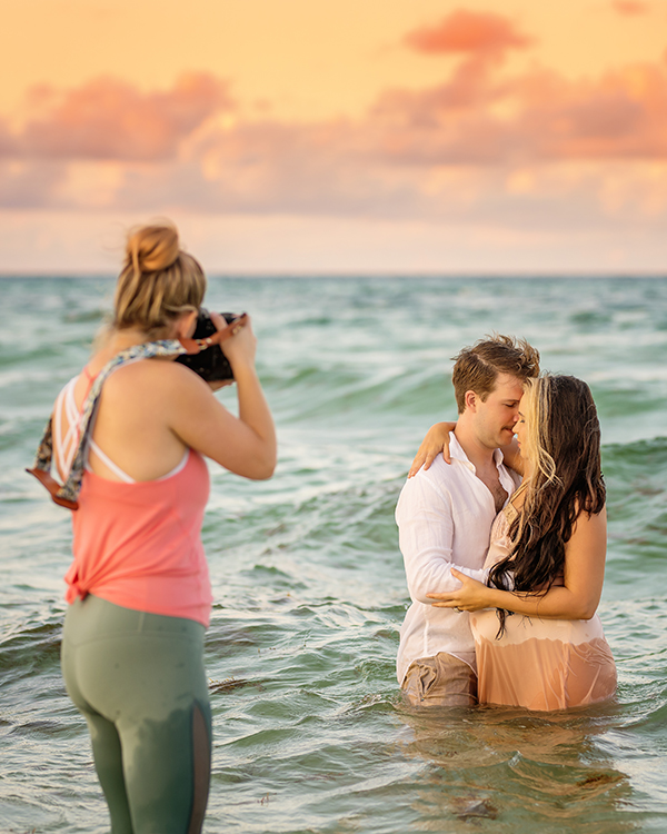 Behind the Scenes in the Gulf | Tampa Family Photographer at Work Behind the scenes of a photographer standing in the Gulf while photographing a family in the water near Tampa, Florida.