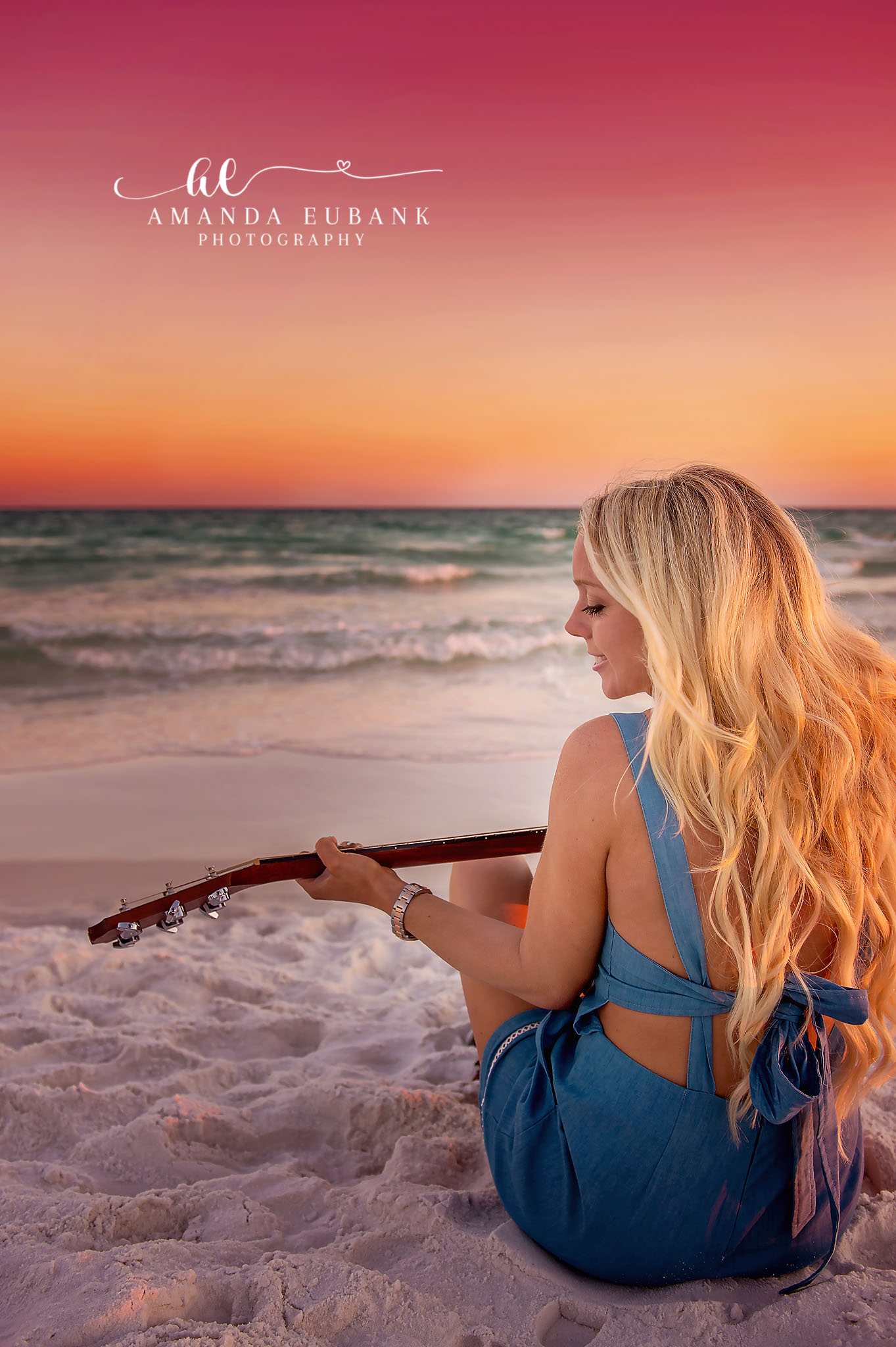 Senior Portrait at Sunset | Senior Portraits in Tampa, FL Tampa senior photographer captures a senior in denim and a white top on the beach beneath a glowing coral sky.