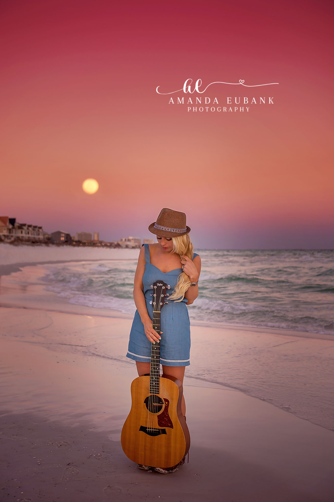 Senior With a Guitar — Tampa Bay Senior Photography A senior holding an acoustic guitar on the shoreline as the sun sits on the horizon at a beach senior session in Tampa, FL.