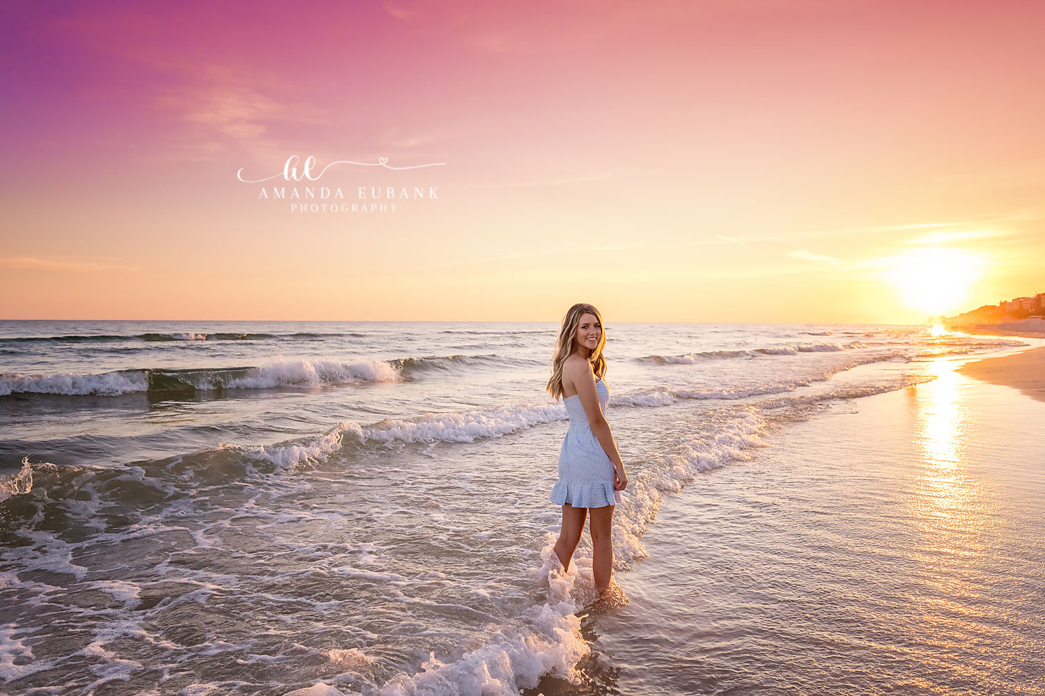 Blue Dress at Sunrise | Senior Portraits in Tampa, FL Tampa senior photographer captures a senior in a light blue dress at the water's edge with the sun low on the horizon.