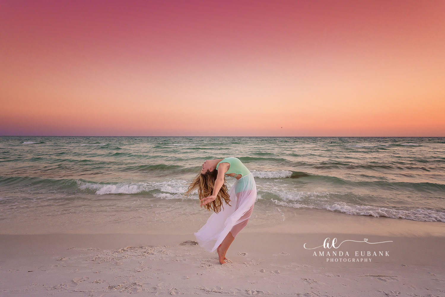 Sheer Wrap in the Breeze — Tampa Bay Senior Photography A senior on the sand with a sheer wrap lifting in the wind at pastel sunset at a beach senior session in Tampa, FL.