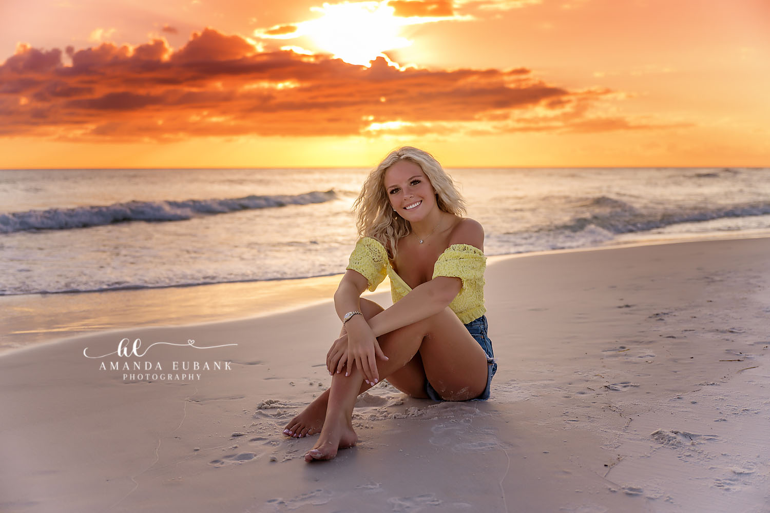 Seated on the Wet Sand — Tampa Bay Senior Photography A senior in yellow seated on the wet sand as the sun burns through the clouds at a beach senior session in Tampa, FL.
