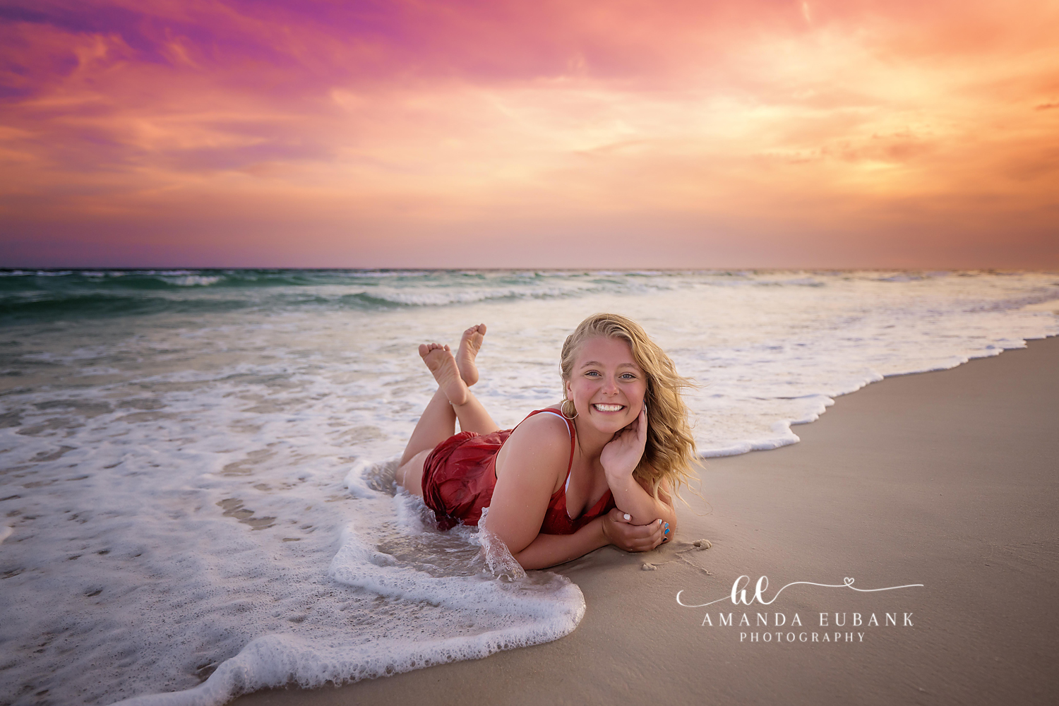 Laughing in the Shallow Surf — Tampa Bay Senior Photography A senior in a red dress lying in the shallow surf laughing as a wave rolls in at a beach senior session in Tampa, FL.