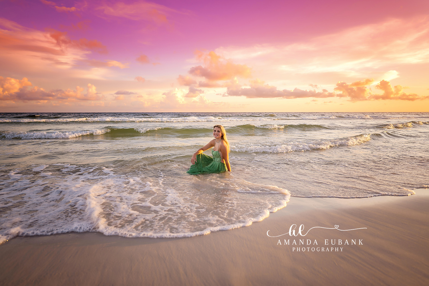 Green Dress at the Water’s Edge — Tampa Bay Senior Photography A senior in a green dress standing in the surf under a glowing pastel sky at a beach senior session in Tampa, FL.