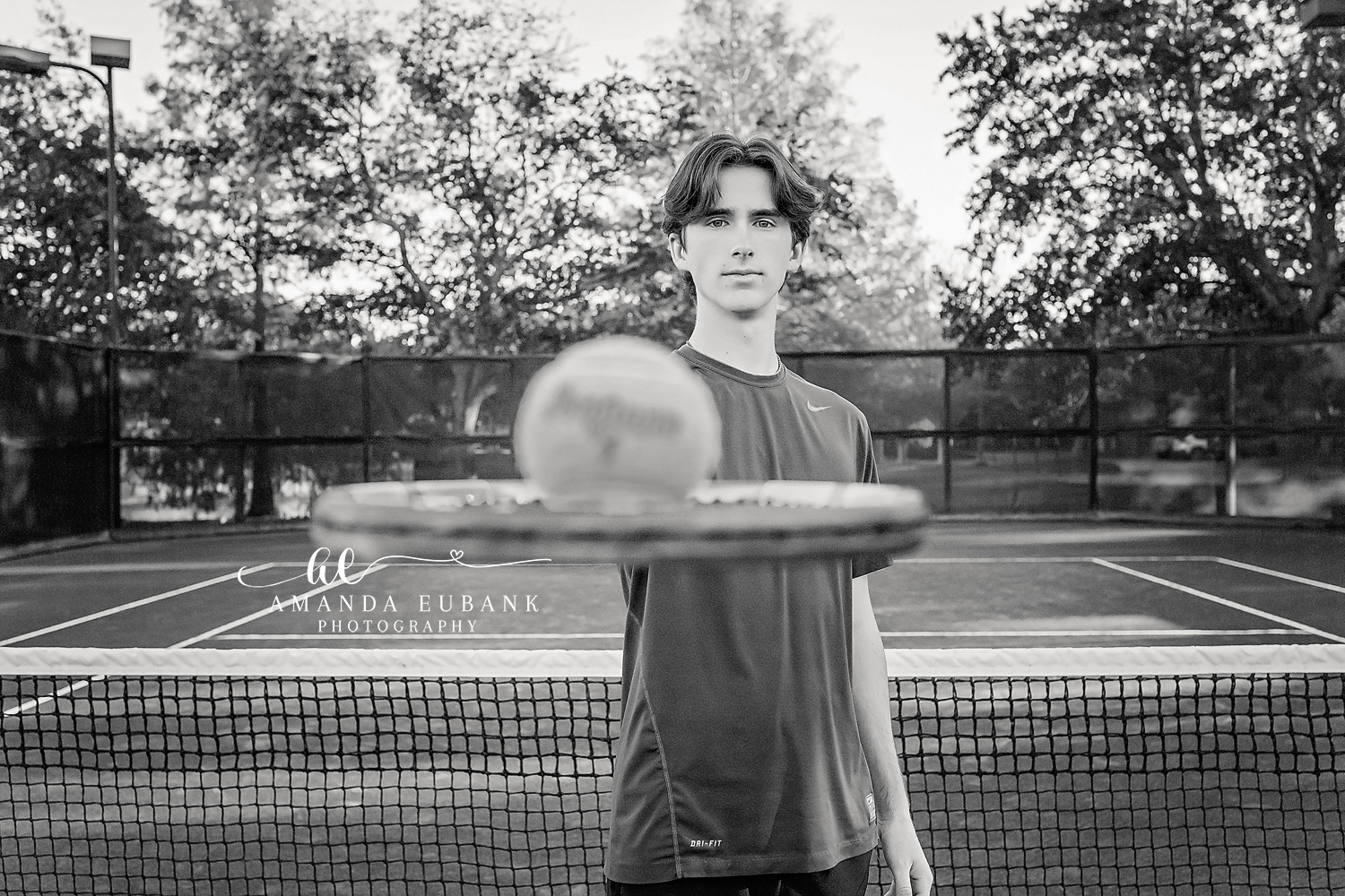Tennis Court Senior Portrait | Tampa Senior Sports Photographer A black and white portrait of a senior athlete holding a ball on a tennis court during a senior session in Tampa, Florida.
