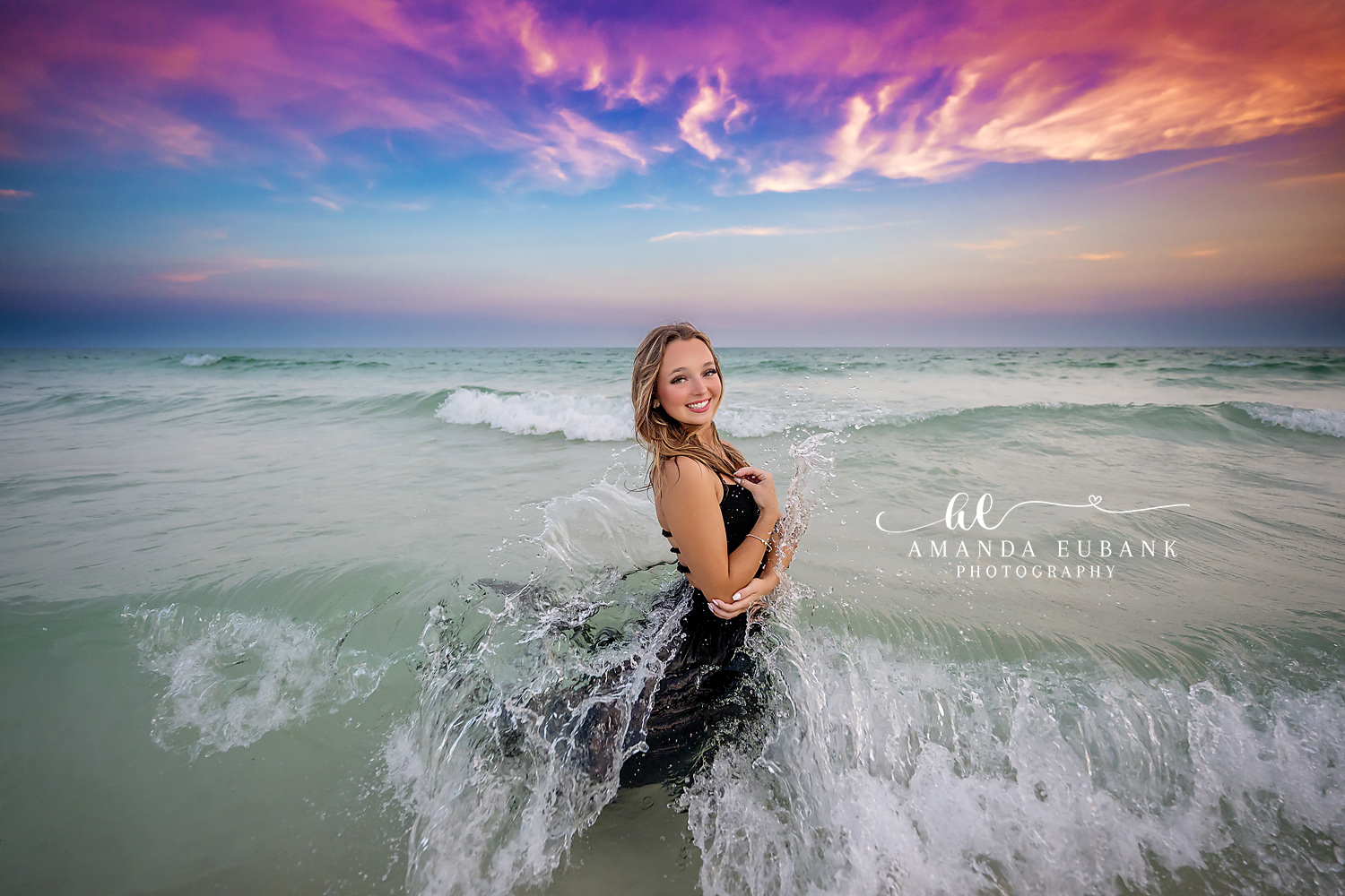 Black Dress in the Waves | Senior Portraits in Tampa, FL Tampa senior photographer captures a senior in a black dress kneeling in the breaking waves under a violet sky.