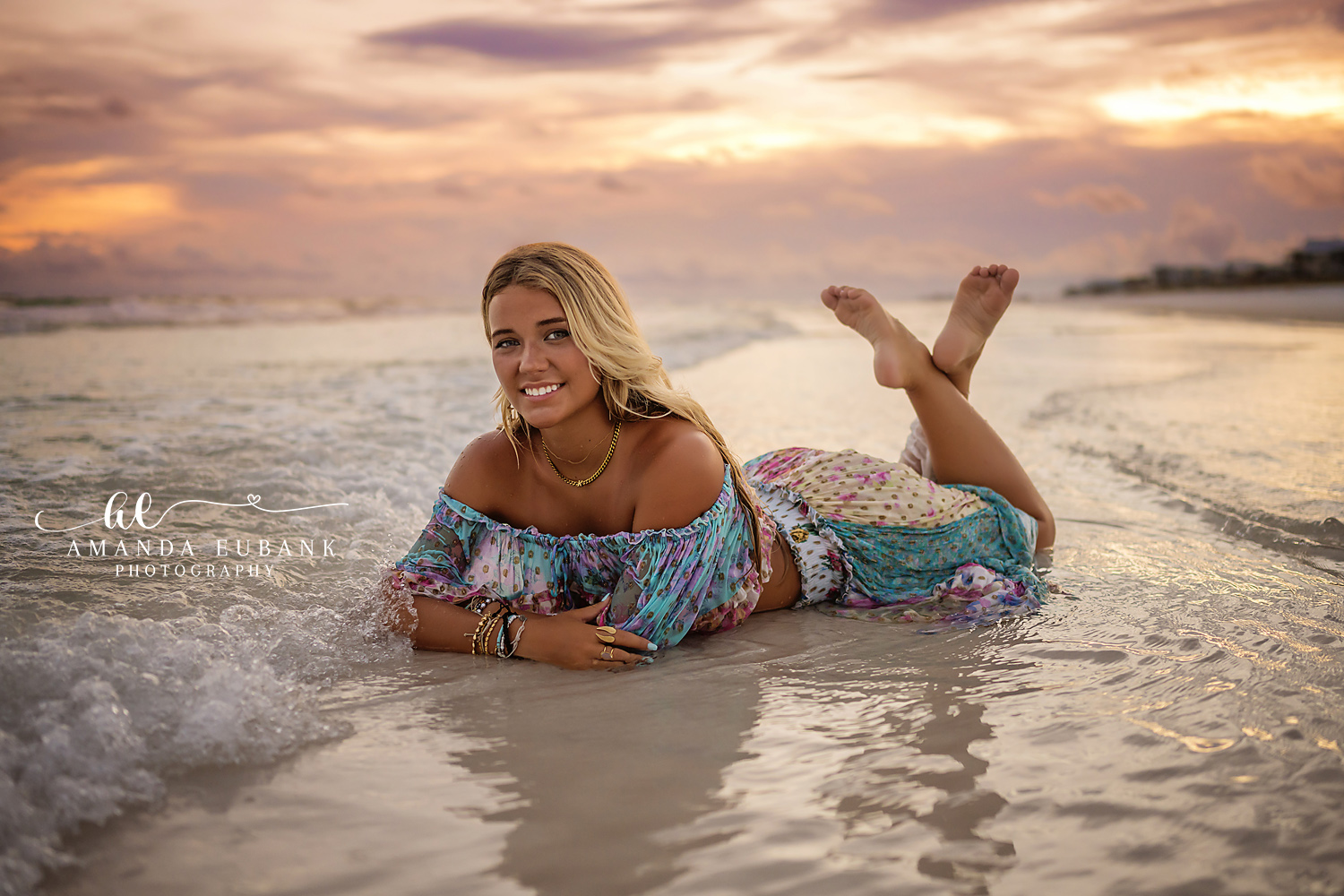 Lying in the Shallow Surf | Tampa Senior Photographer A laughing senior lying in the shallow surf in a floral maxi dress during a senior portrait session in Tampa, Florida.