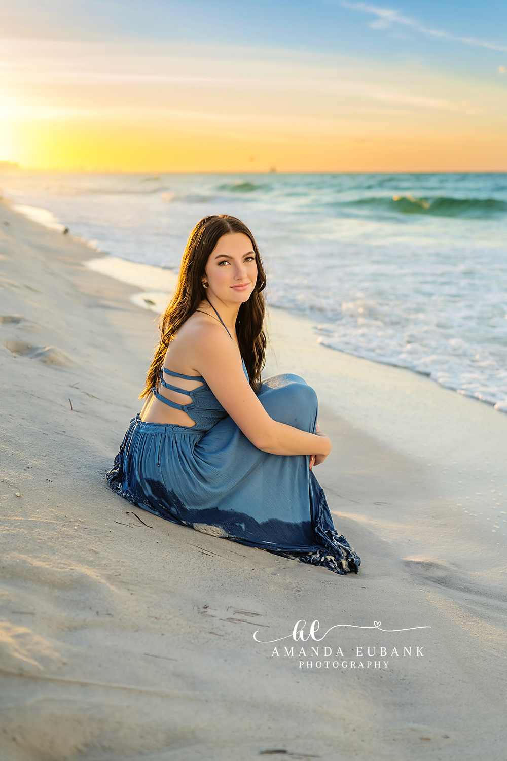 Blue Skirt on the Shoreline | Senior Portraits in Tampa, FL Tampa senior photographer captures a senior in a blue skirt seated on the shoreline in warm evening light.
