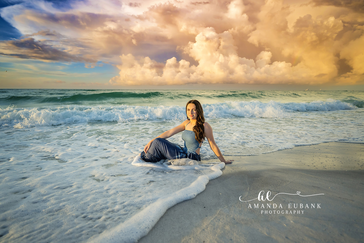 Seated in the White Water | Tampa Senior Photographer A senior in a navy gown seated as white water rushes around her during a senior portrait session in Tampa, Florida.