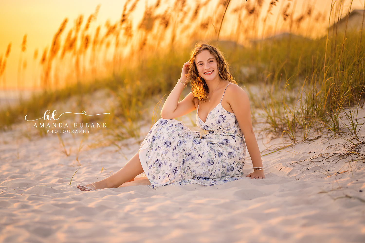 Sea Oats at Golden Hour | Senior Portraits in Tampa, FL Tampa senior photographer captures a senior in a floral dress seated in glowing sea oats at golden hour.