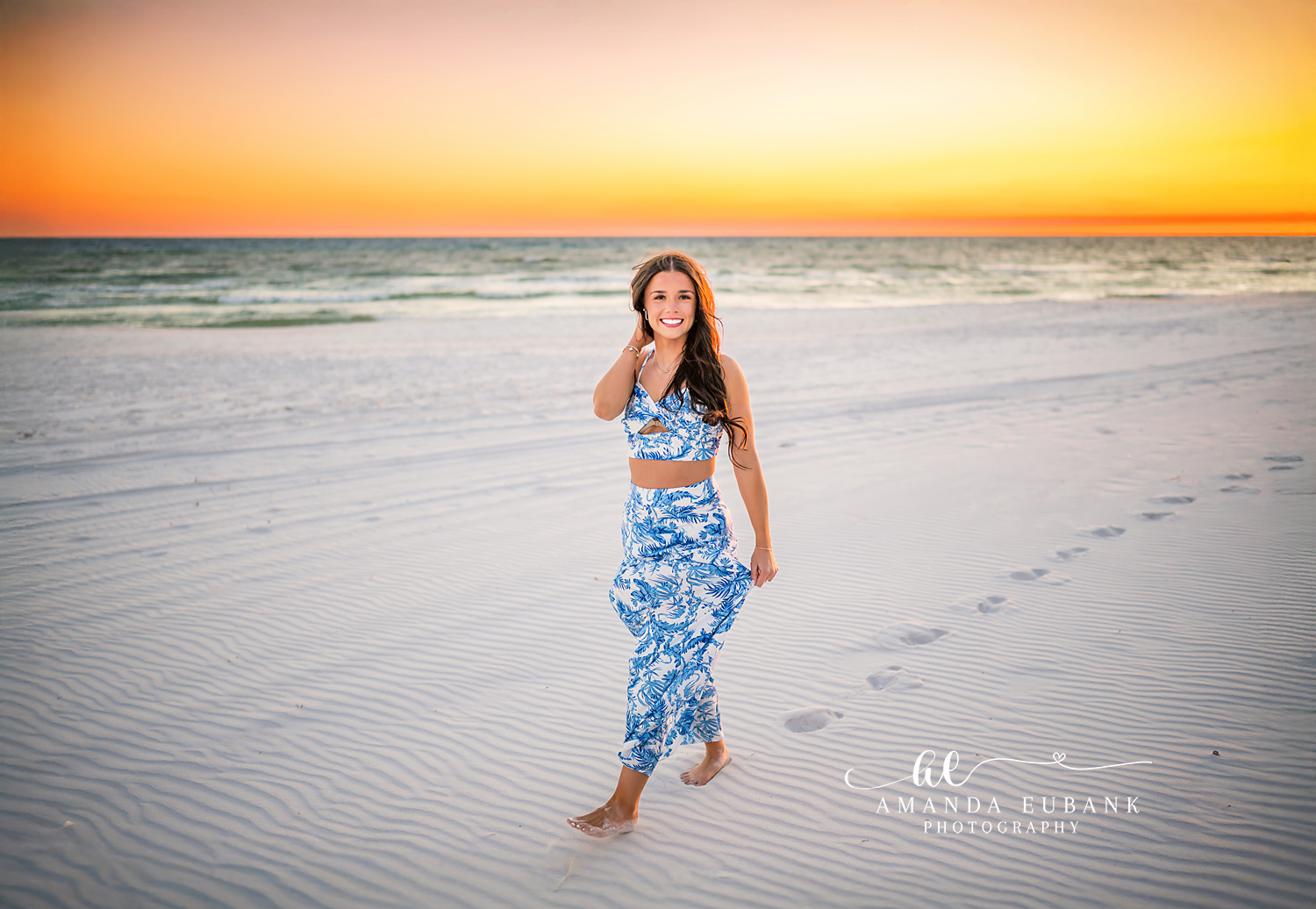 Blue Floral Set on the Sand | Senior Portraits in Tampa, FL Tampa senior photographer captures a senior in a blue floral two-piece standing on the sand at golden hour.