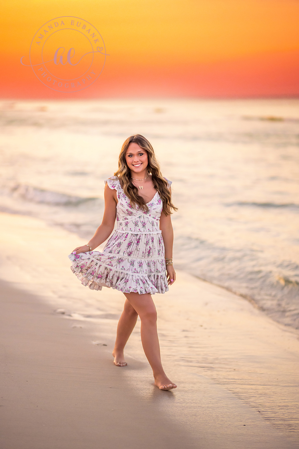 Backlit in a Floral Dress | Senior Portraits in Tampa, FL Tampa senior photographer captures a senior in a floral dress on the shoreline backlit by a fiery sunset.