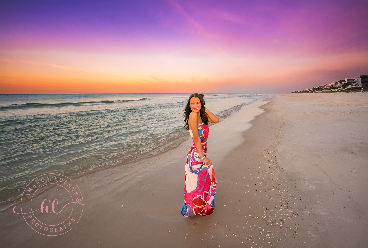 Walking the Shore at Twilight | Beach Senior Session in Tampa, Florida Senior pictures in Tampa Bay showing a senior in a pink gown walking the shoreline as twilight settles over the Gulf.