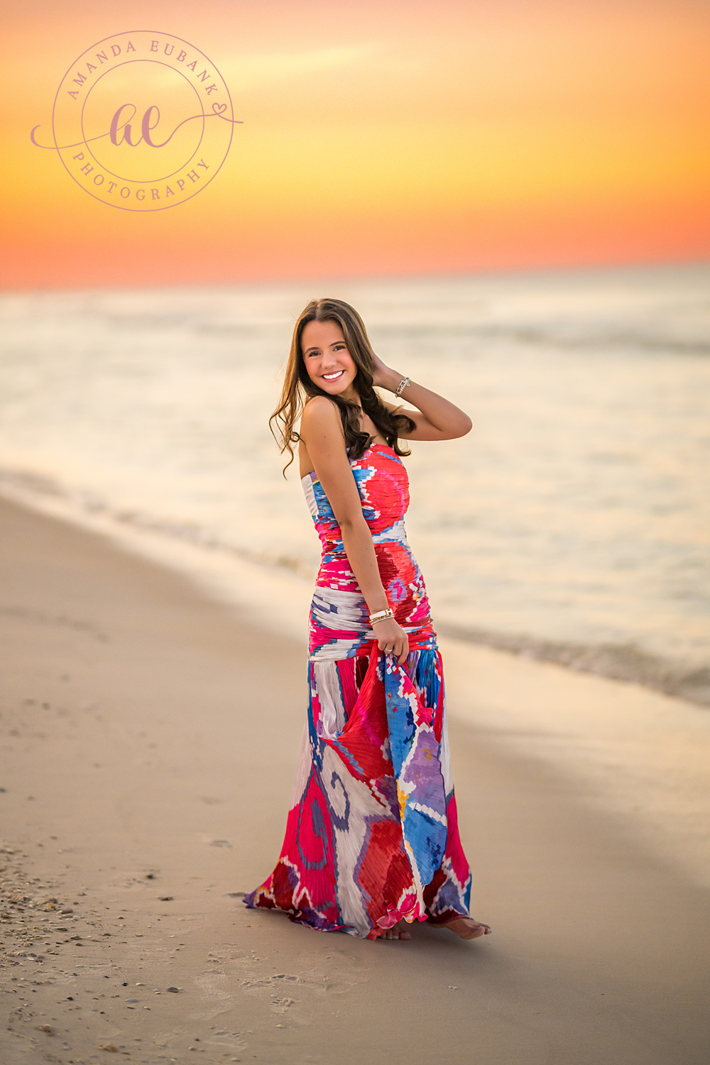 Wind in Her Hair | Senior Portraits in Tampa, FL Tampa senior photographer captures a senior in a pink gown on the sand with her hair lifting in the sea breeze.