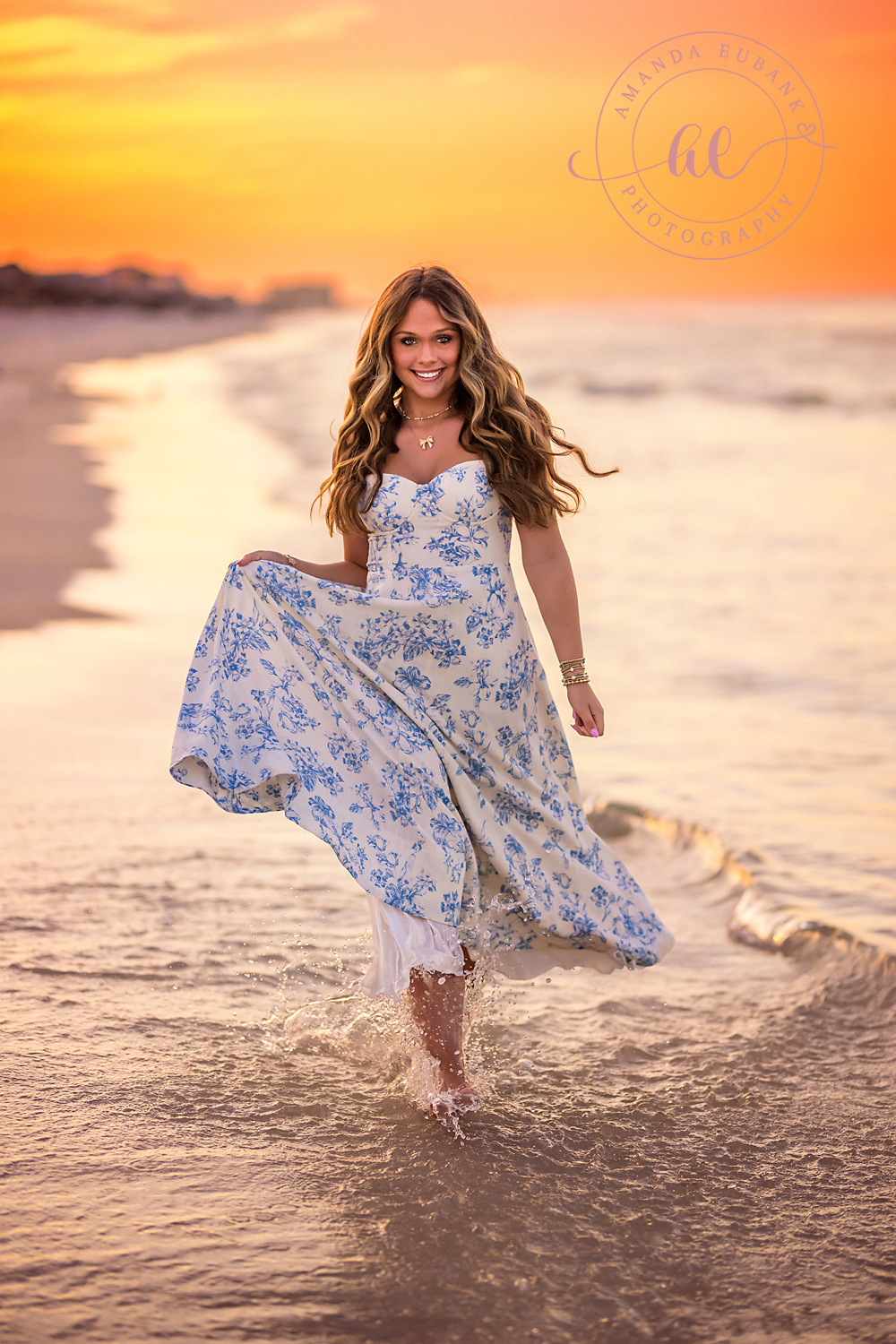 Blue Floral Gown at Sunset — Tampa Bay Senior Photography A senior in a blue floral gown walking the wet sand under a golden sky at a beach senior session in Tampa, FL.