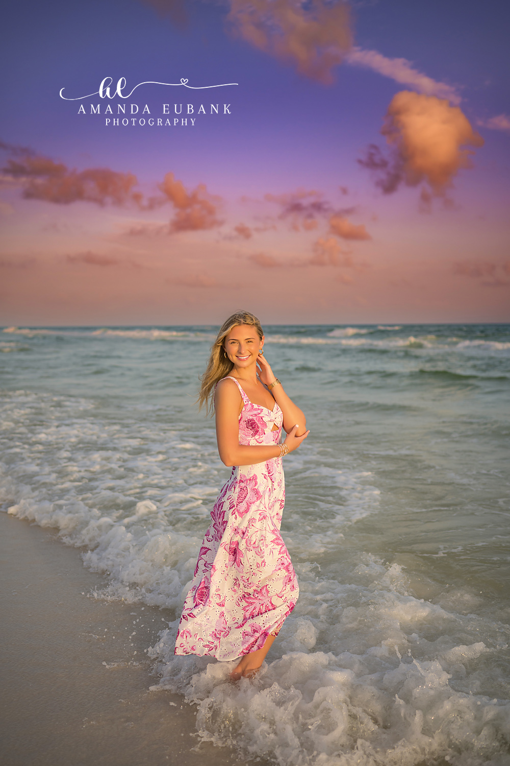 Floral Gown in the Surf — Tampa Bay Senior Photography A senior in a floral gown standing in the surf beneath a purple cloudscape at a beach senior session in Tampa, FL.