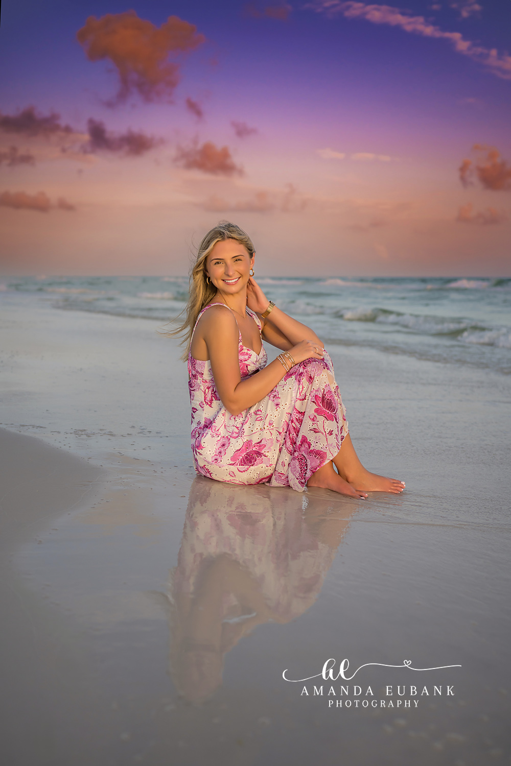 Reflected in the Shallows | Tampa Senior Photographer A senior in a floral gown seated on the wet sand with her reflection below during a senior portrait session in Tampa, Florida.
