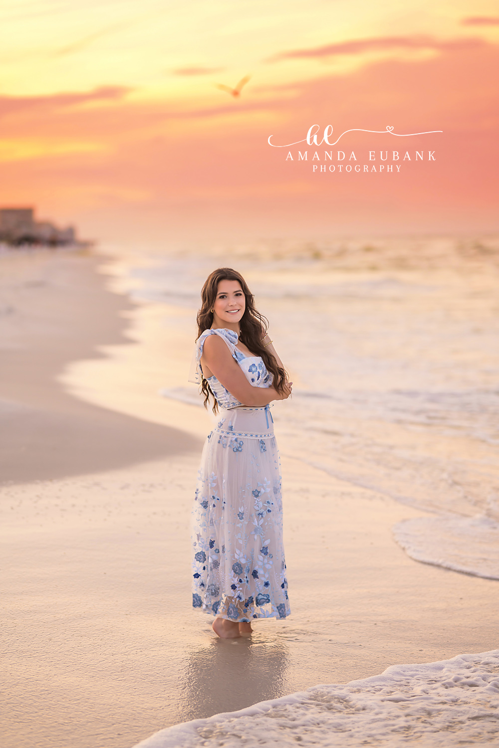Floral Maxi in the Shallows | Beach Senior Session in Tampa, Florida Senior pictures in Tampa Bay showing a senior in a floral maxi dress standing in the shallows at coral sunset.