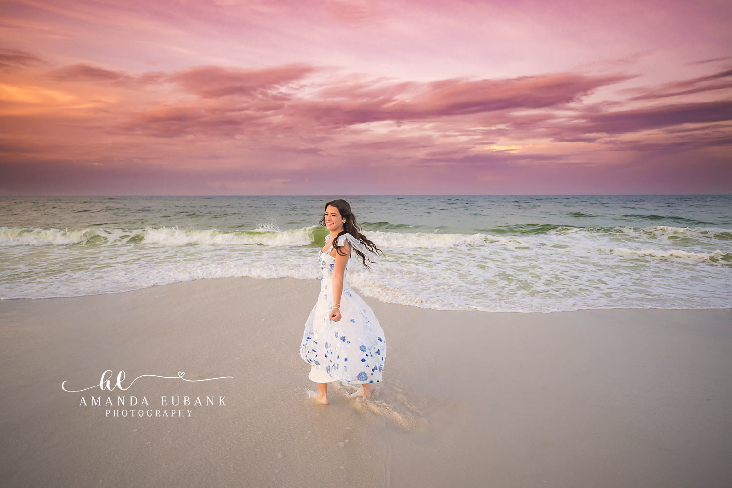 Walking Through the Surf at Dusk | Senior Portraits in Tampa, FL Tampa senior photographer captures a senior in a floral maxi dress walking through the surf under a rose sky.