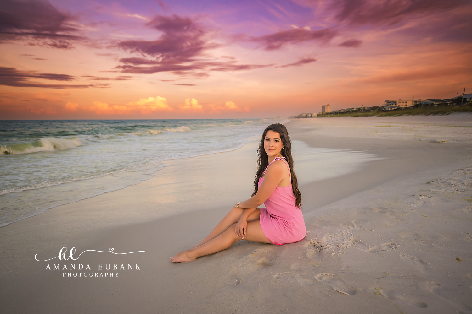 Pink Dress at Twilight | Tampa Senior Photographer A senior in a pink dress seated on the wet sand as twilight colors the sky during a senior portrait session in Tampa, Florida.
