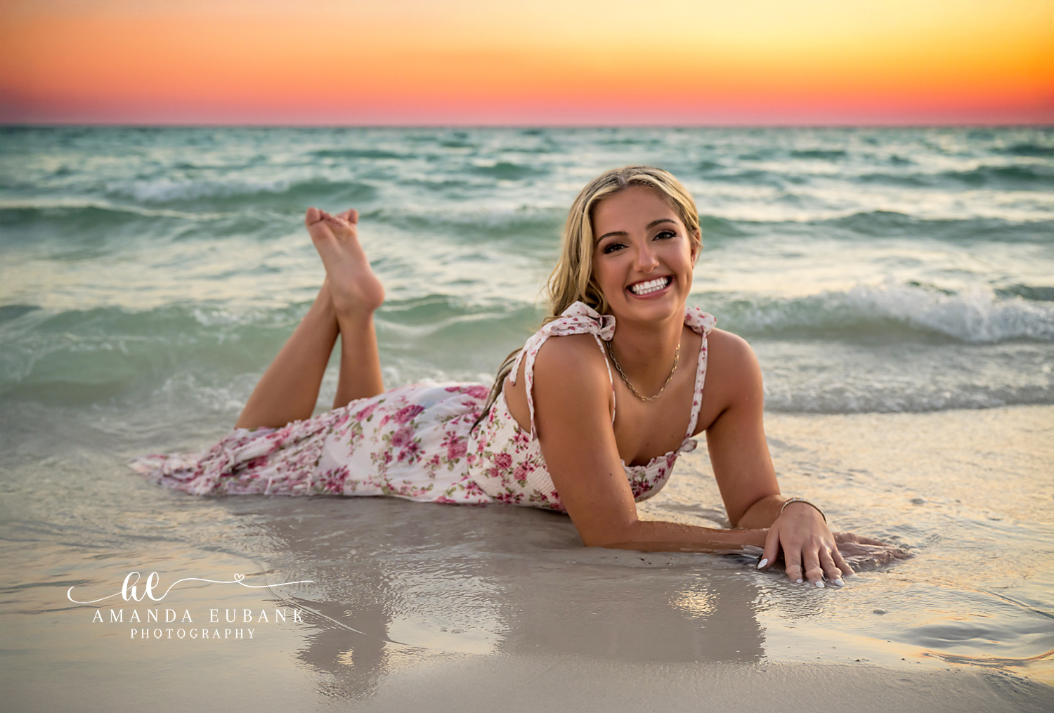 Golden Sky Beach Portrait | Senior Portraits in Tampa, FL Tampa senior photographer captures a senior in a floral dress lying on the sand beneath a glowing gold horizon.
