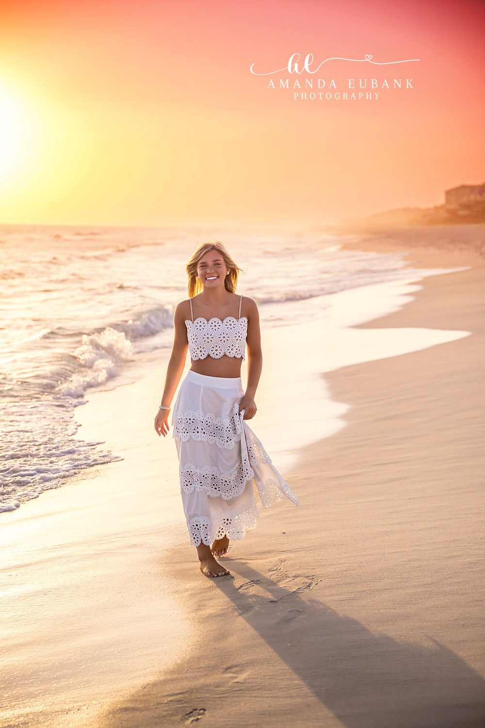 Walking the Sunlit Shore | Tampa Senior Photographer A senior in a white skirt walking the shoreline as the sun floods the beach during a senior portrait session in Tampa, Florida.