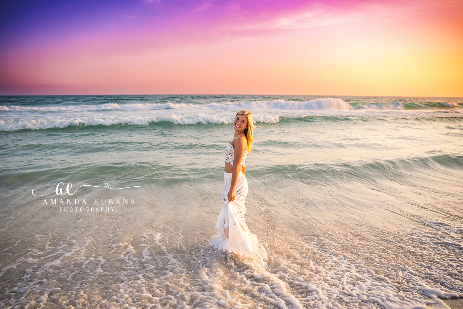 White Skirt at Violet Sunset — Tampa Bay Senior Photography A senior in a white skirt standing in the surf beneath a violet and gold sky at a beach senior session in Tampa, FL.