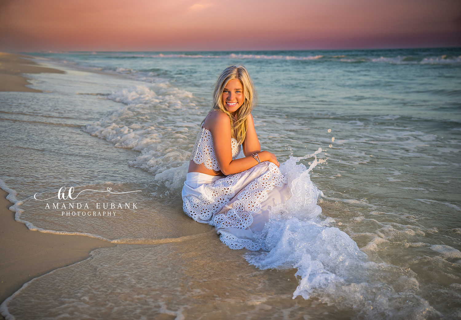 Sea Foam Around Her Skirt | Tampa Senior Photographer A senior seated on the sand as sea foam swirls around her white skirt during a senior portrait session in Tampa, Florida.