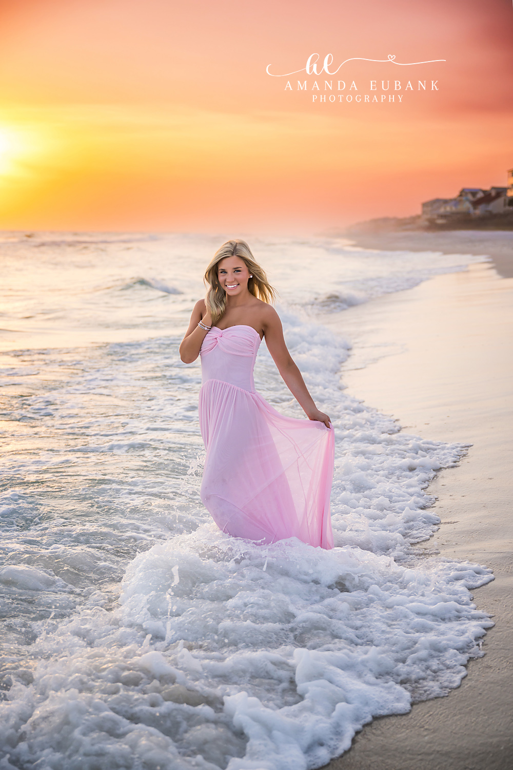 Foam Around a Pink Gown | Beach Senior Session in Tampa, Florida Senior pictures in Tampa Bay showing a senior in a pink gown standing in foaming surf under a golden sky.