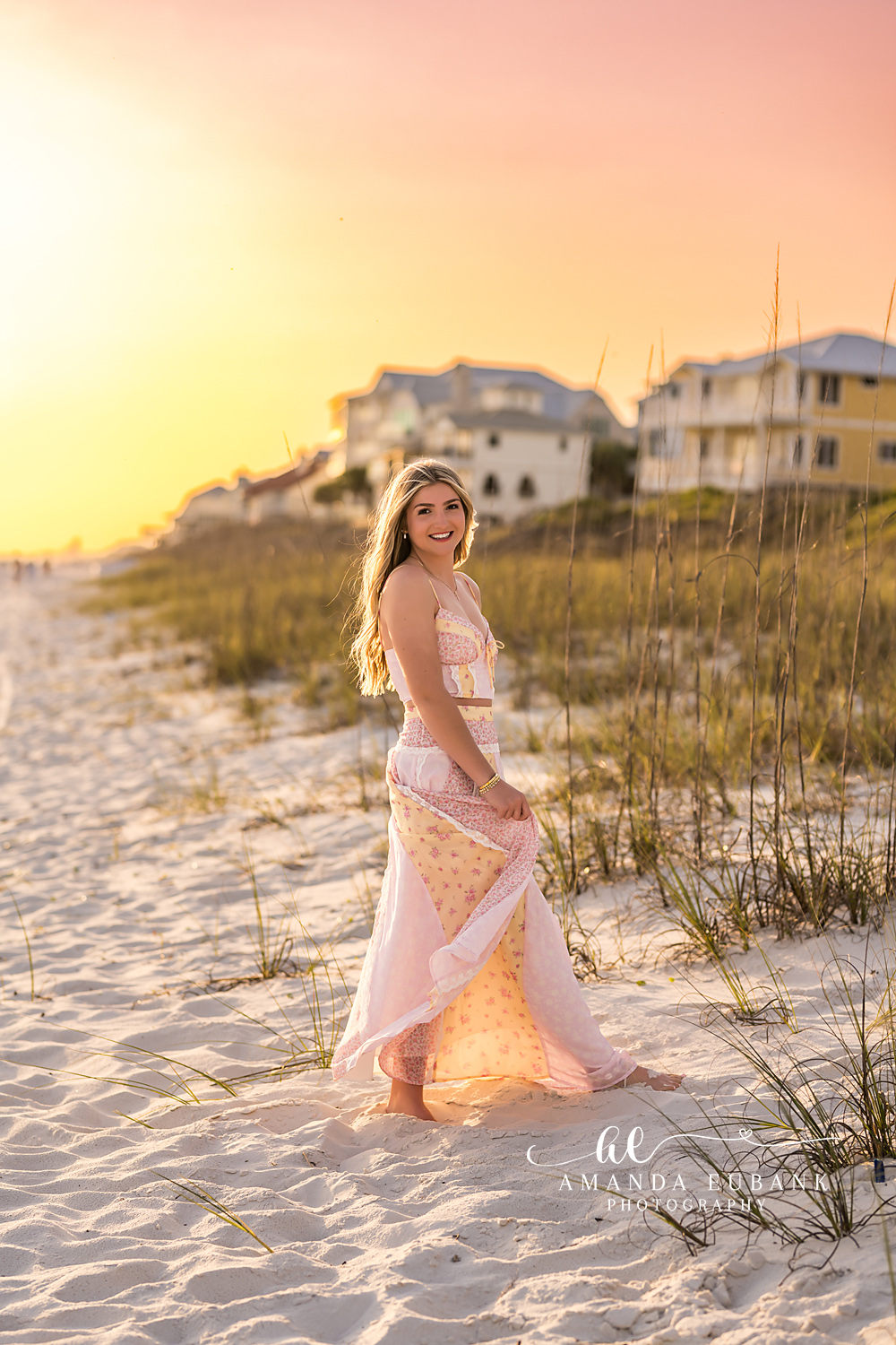 Blush Gown by the Dunes | Senior Portraits in Tampa, FL Tampa senior photographer captures a senior in a blush gown standing in the dunes with beach houses behind.