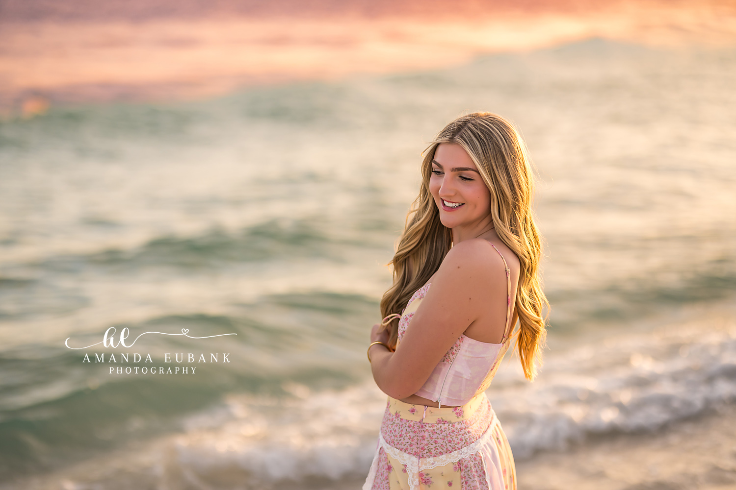Blush Gown by the Waves | Tampa Senior Photographer A senior in a blush gown standing before the breaking waves at sunset during a senior portrait session in Tampa, Florida.