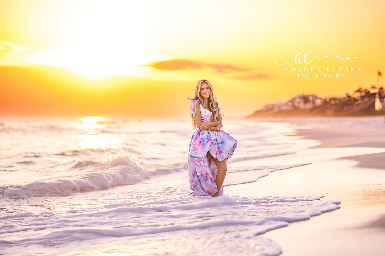 Kneeling in the Golden Surf | Senior Portraits in Tampa, FL Tampa senior photographer captures a senior in a printed gown kneeling in the surf as the sun blazes gold.